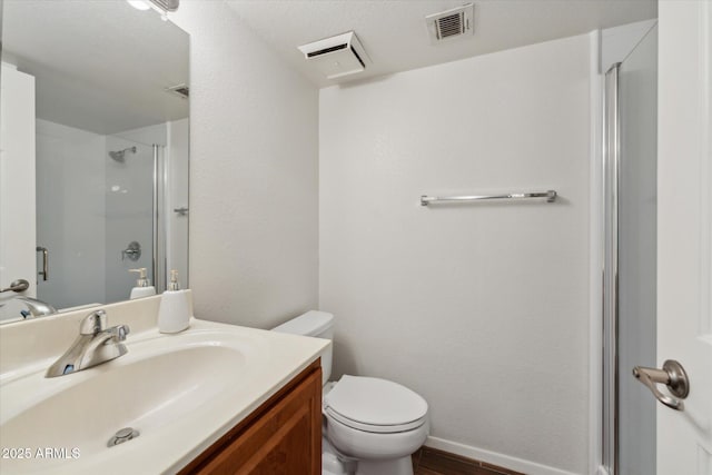 bathroom with toilet, a stall shower, visible vents, and vanity