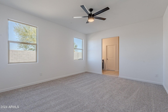 carpeted spare room featuring ceiling fan