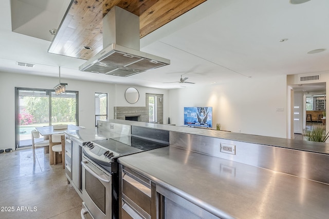 5239 E Waltann Ln, Scottsdale, AZ 85254 - kitchen featuring island exhaust hood, electric stove, a fireplace, ceiling fan, and open floor plan