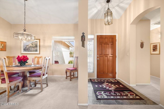 carpeted entrance foyer with a chandelier