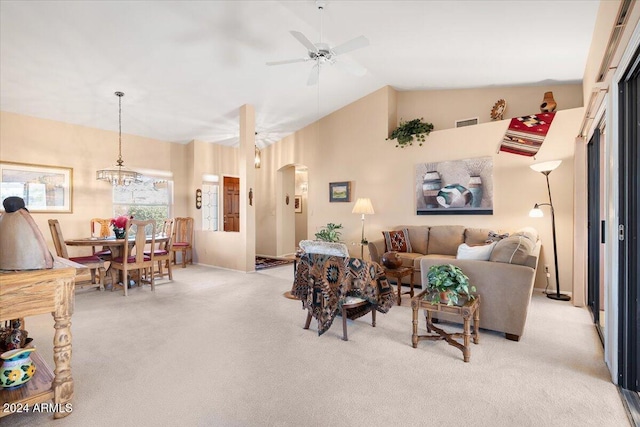 living room featuring light carpet, vaulted ceiling, and ceiling fan with notable chandelier