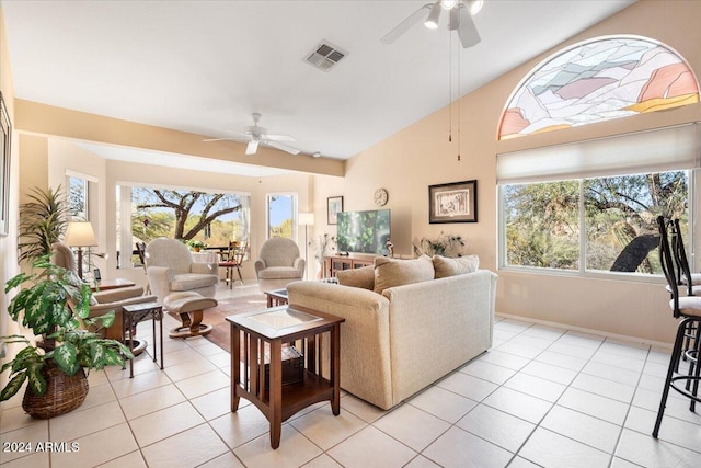 tiled living room featuring vaulted ceiling, ceiling fan, and a healthy amount of sunlight