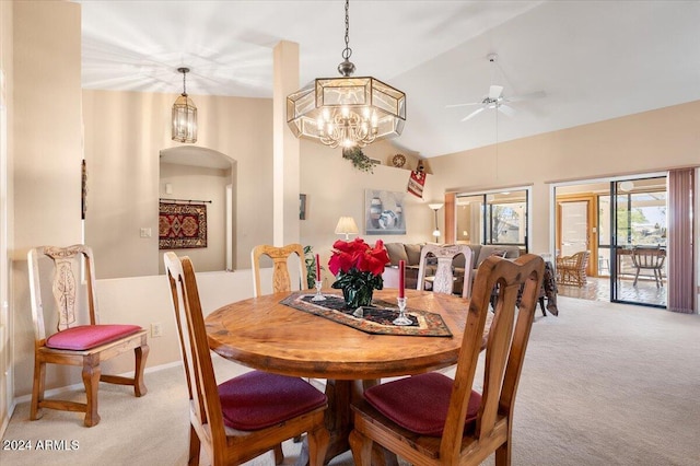 dining room featuring ceiling fan with notable chandelier, lofted ceiling, and light carpet