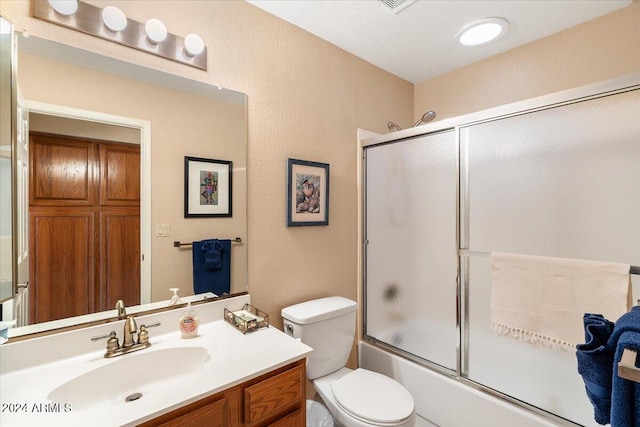 full bathroom with toilet, combined bath / shower with glass door, and vanity