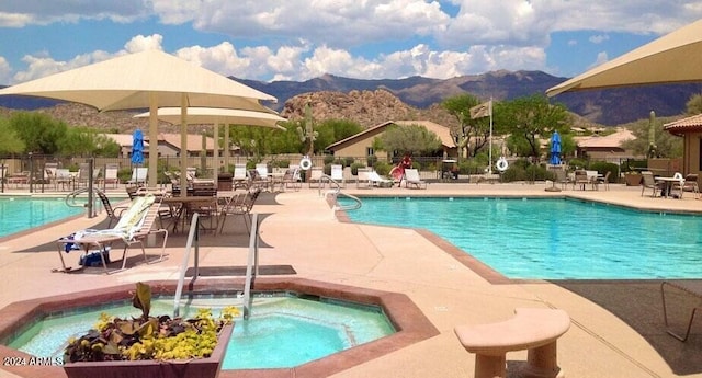 view of pool with a mountain view, a hot tub, and a patio