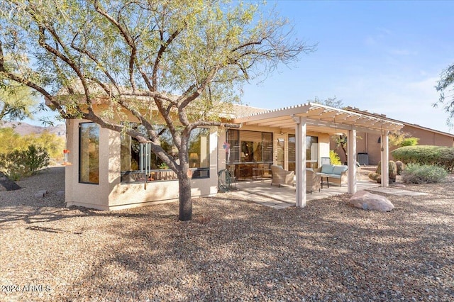 back of house with a pergola, an outdoor living space, and a patio