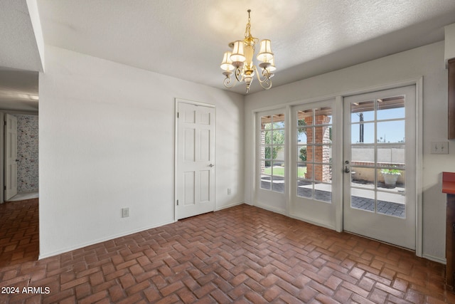 interior space with a notable chandelier and a textured ceiling