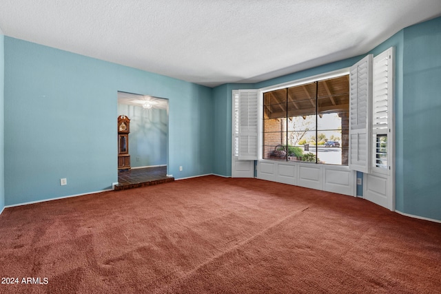 carpeted spare room with a textured ceiling