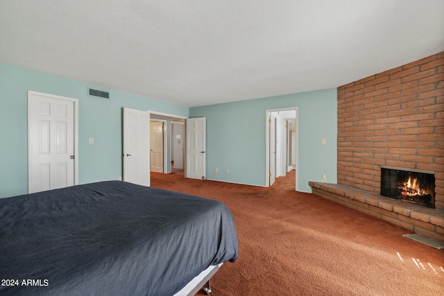 unfurnished bedroom with carpet floors, a textured ceiling, and a fireplace