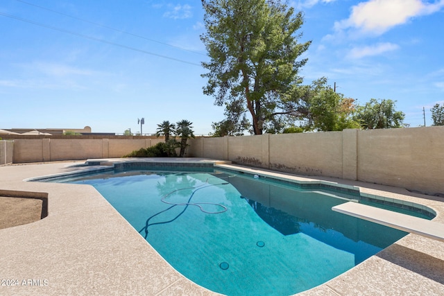 view of swimming pool featuring a diving board