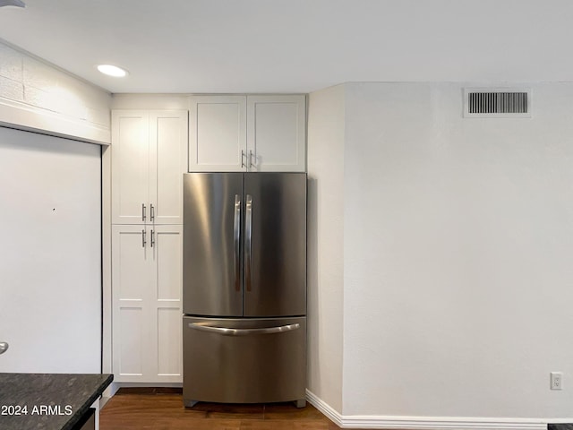 kitchen with stainless steel refrigerator, white cabinetry, and dark hardwood / wood-style flooring