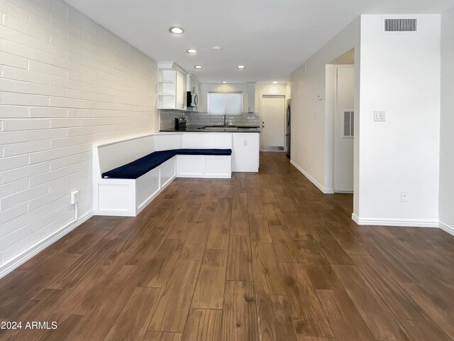 kitchen featuring appliances with stainless steel finishes, dark hardwood / wood-style floors, tasteful backsplash, sink, and white cabinets