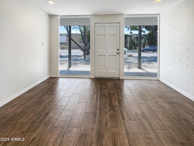 interior space with floor to ceiling windows, dark wood-type flooring, and a wealth of natural light