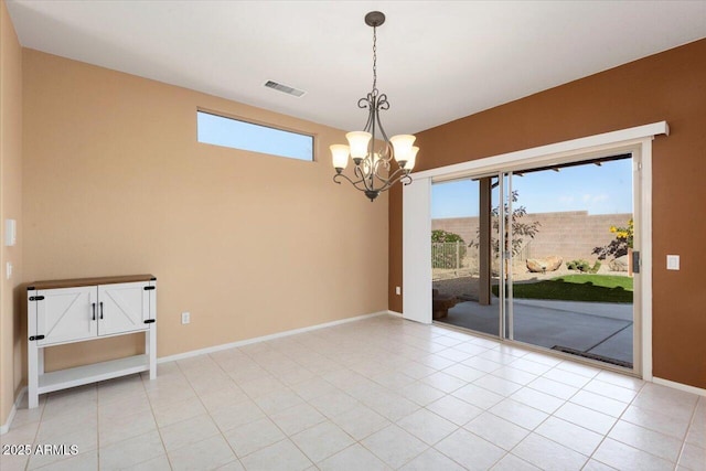 empty room featuring light tile patterned flooring and a chandelier