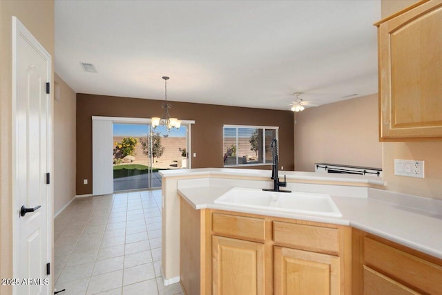 kitchen featuring light brown cabinets, light tile patterned flooring, ceiling fan with notable chandelier, and sink