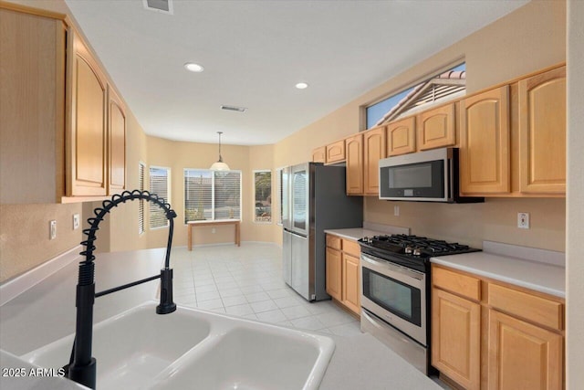 kitchen featuring light brown cabinets, sink, hanging light fixtures, light tile patterned floors, and stainless steel appliances