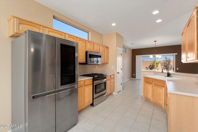 kitchen featuring light brown cabinets, sink, hanging light fixtures, a notable chandelier, and stainless steel appliances