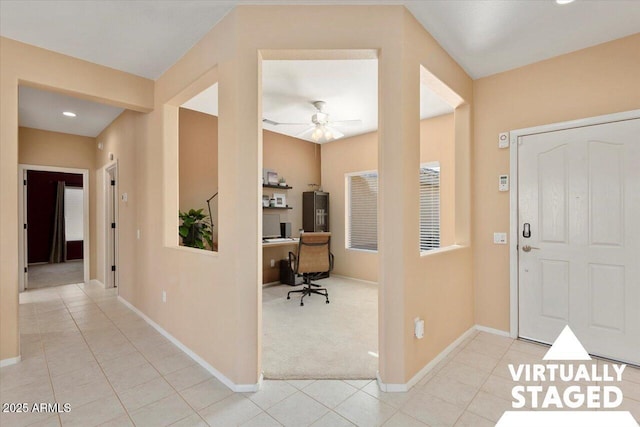 foyer entrance featuring light colored carpet and ceiling fan