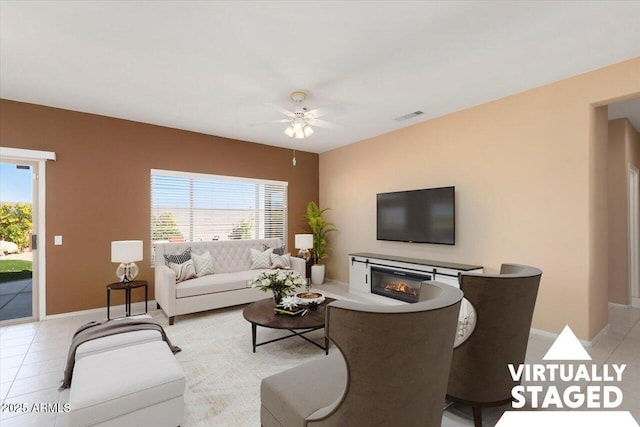 living room with a wealth of natural light, ceiling fan, and light tile patterned flooring