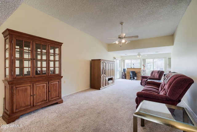 living room featuring ceiling fan, vaulted ceiling, light carpet, and a textured ceiling