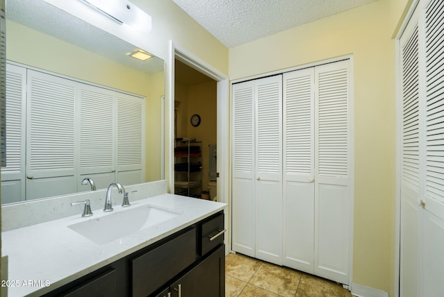 bathroom with vanity, tile patterned flooring, and a textured ceiling