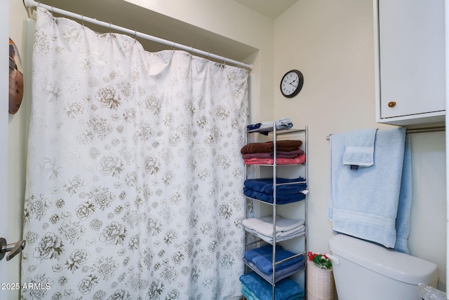 bathroom featuring a shower with curtain and toilet