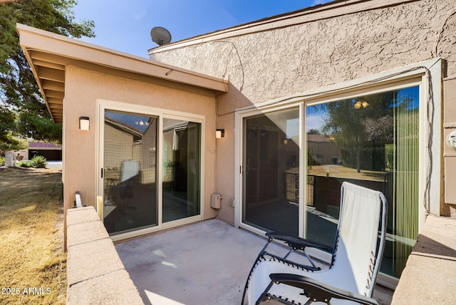 view of exterior entry with a patio area