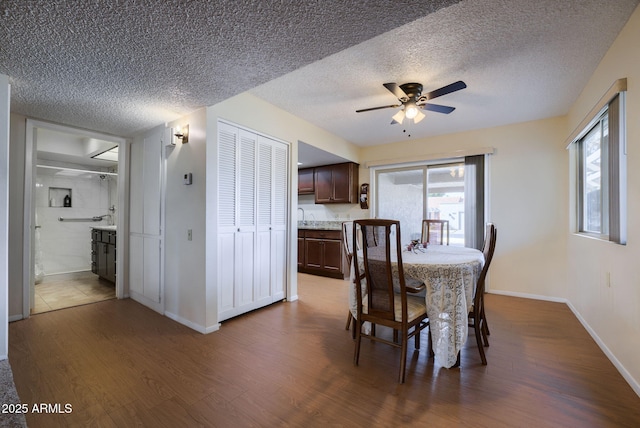 dining room with a textured ceiling, dark hardwood / wood-style floors, and ceiling fan