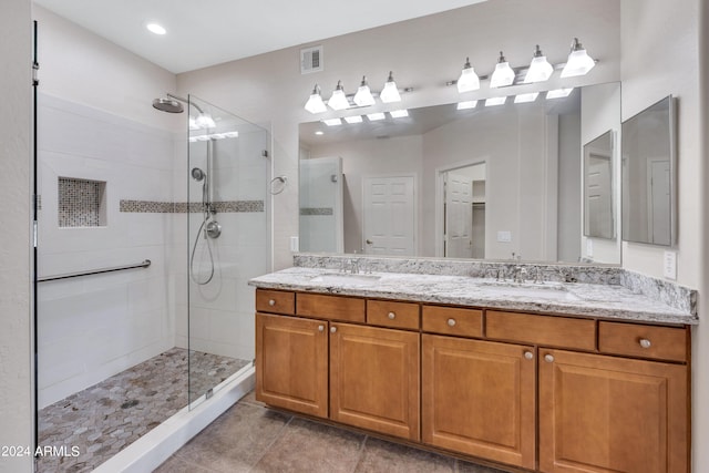 bathroom with tile patterned flooring, walk in shower, and vanity