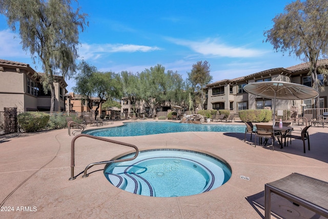 view of pool featuring a hot tub and a patio