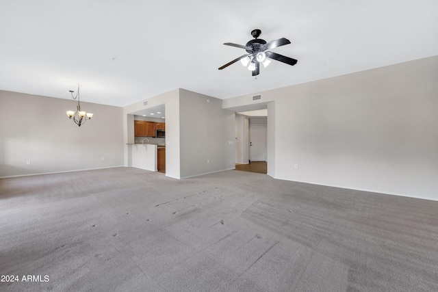 unfurnished living room featuring light colored carpet and ceiling fan with notable chandelier