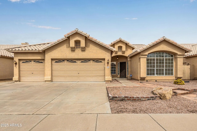 view of front facade featuring stucco siding, an attached garage, a tile roof, and driveway