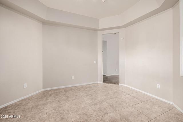 spare room with baseboards and light tile patterned flooring