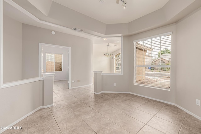 unfurnished room with visible vents, baseboards, light tile patterned flooring, and rail lighting