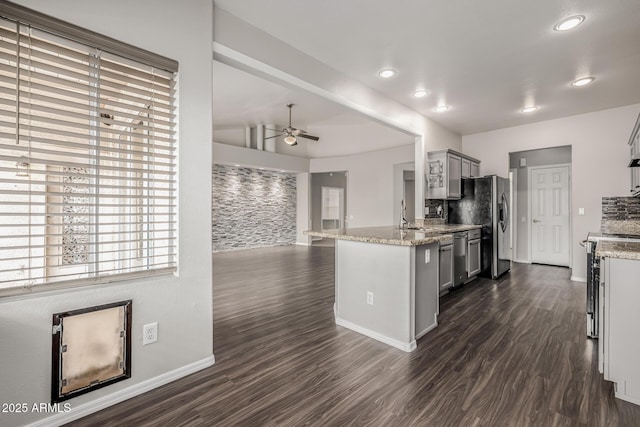 kitchen featuring dark wood-style floors, gray cabinets, appliances with stainless steel finishes, and a ceiling fan