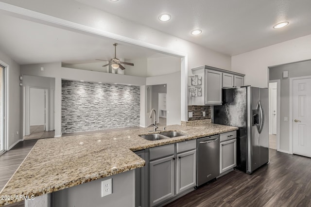 kitchen with ceiling fan, light stone counters, gray cabinets, appliances with stainless steel finishes, and a sink