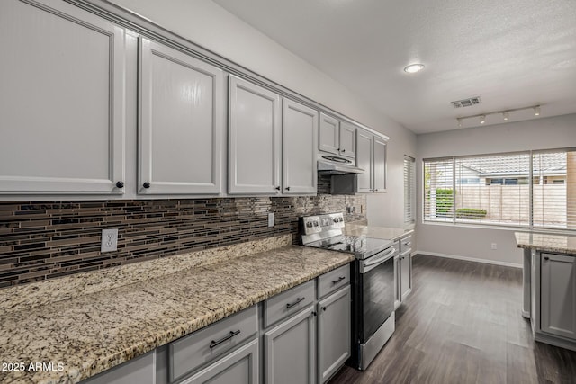 kitchen featuring visible vents, gray cabinets, electric stove, under cabinet range hood, and tasteful backsplash