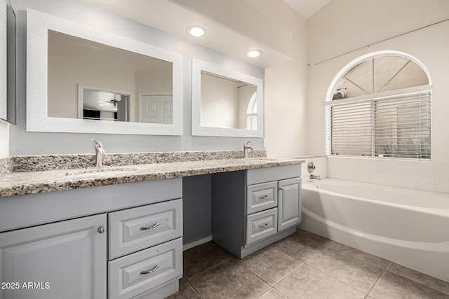 bathroom featuring tile patterned flooring, double vanity, a garden tub, and a sink