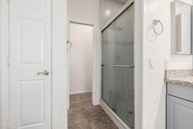 full bath with a stall shower, vanity, and tile patterned flooring