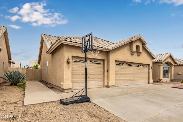 view of front of property with stucco siding, fence, concrete driveway, a garage, and a tiled roof