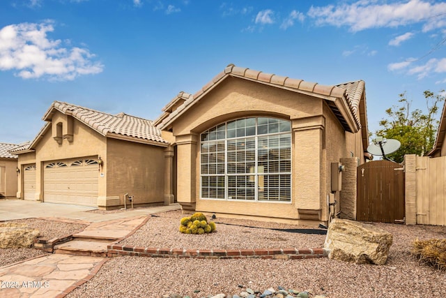 view of front of house with a tiled roof, stucco siding, and a gate