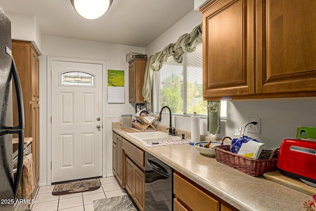1951 E Del Sur Dr, Tempe, AZ 85283 - kitchen featuring dishwasher, freestanding refrigerator, light tile patterned floors, brown cabinetry, and light countertops