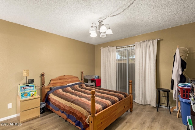 1951 E Del Sur Dr, Tempe, AZ 85283 - bedroom featuring a chandelier, wood finished floors, and a textured ceiling