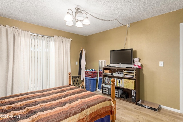 1951 E Del Sur Dr, Tempe, AZ 85283 - bedroom with a chandelier, wood finished floors, and a textured ceiling