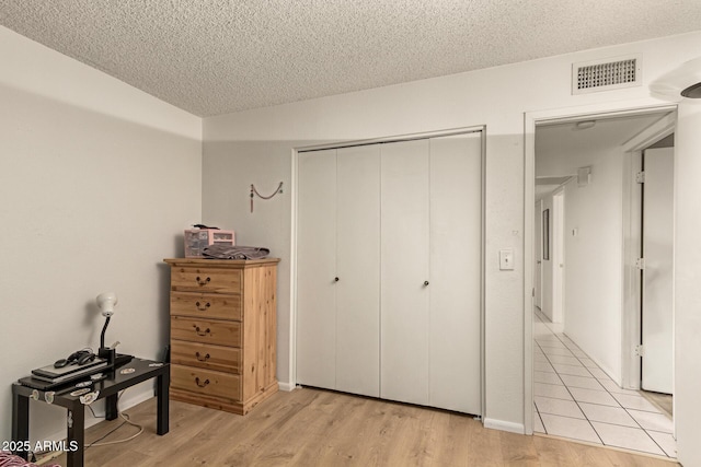1951 E Del Sur Dr, Tempe, AZ 85283 - bedroom featuring a textured ceiling, a closet, and light wood-style flooring