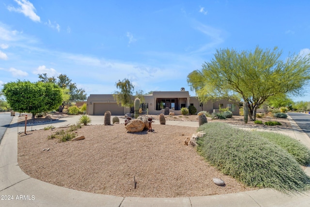 pueblo revival-style home with a garage