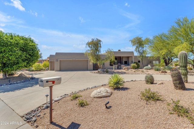 pueblo revival-style home with a garage