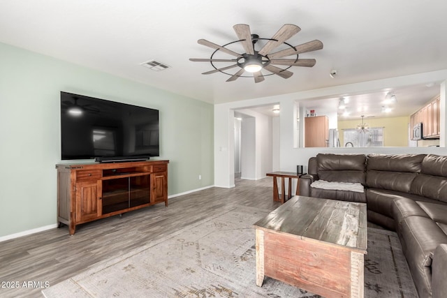 living room featuring light hardwood / wood-style floors and ceiling fan