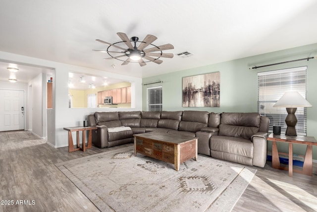 living room featuring ceiling fan and hardwood / wood-style floors