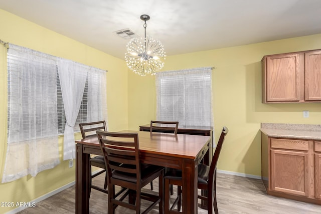 dining area featuring a notable chandelier and light hardwood / wood-style flooring